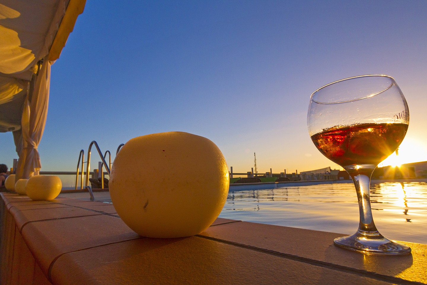 Cocktail by the Gloria Palace San Agustin rooftop pool at sunset